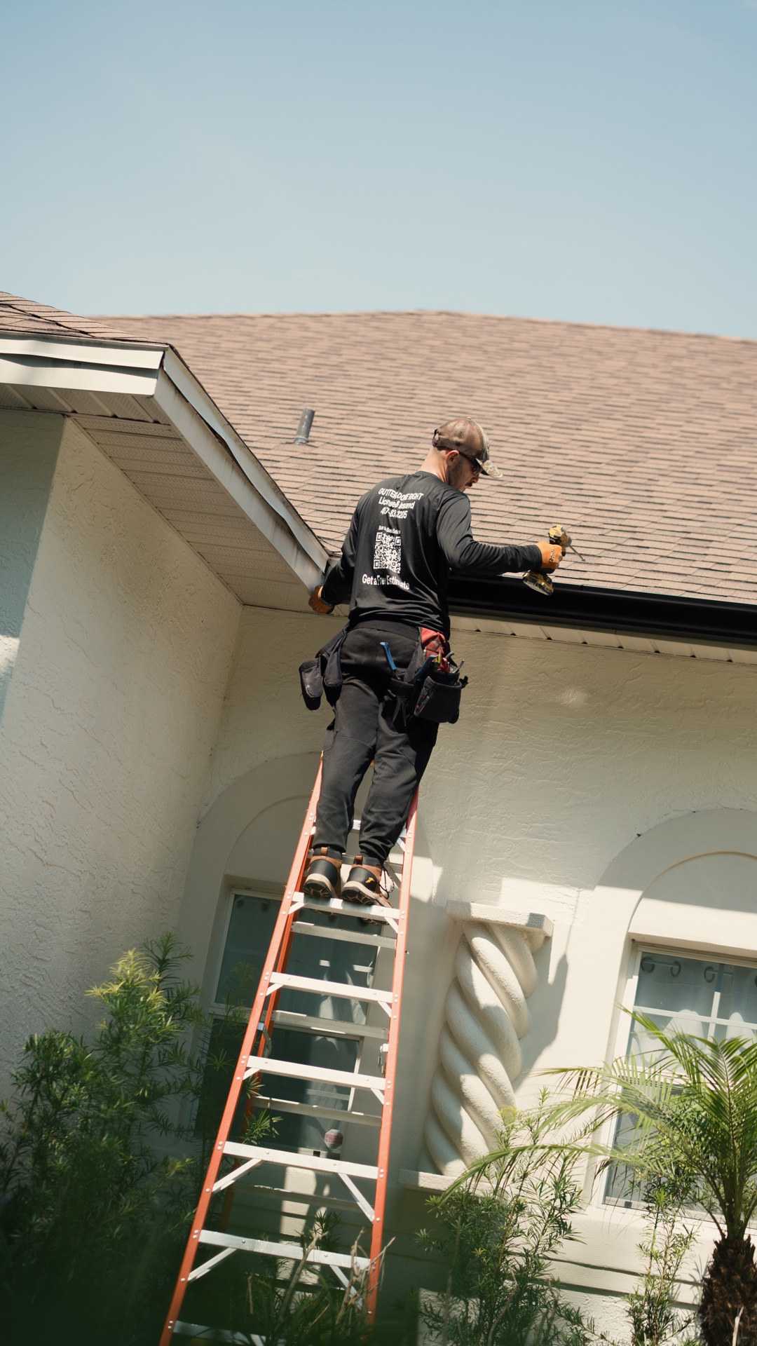 PrimeFlow installer on a ladder reviewing a Florida roofline
